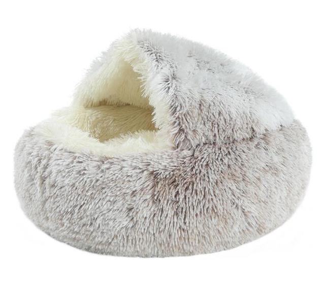 A round, fluffy faux fur pet bed in a light gray and white shaggy pattern, featuring a cream-colored plush interior, shown on a solid white background.